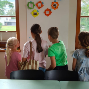 Dizieci ogladają galerię wykonanych przez siebie ramek, zaprezentowaną na tablicy magnetycznej