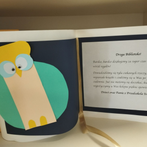 Laurka od dzieci i pracowników przedszkola, z wizerunkiem sowy oraz podziękowaniem za wizytę w bibliotece 